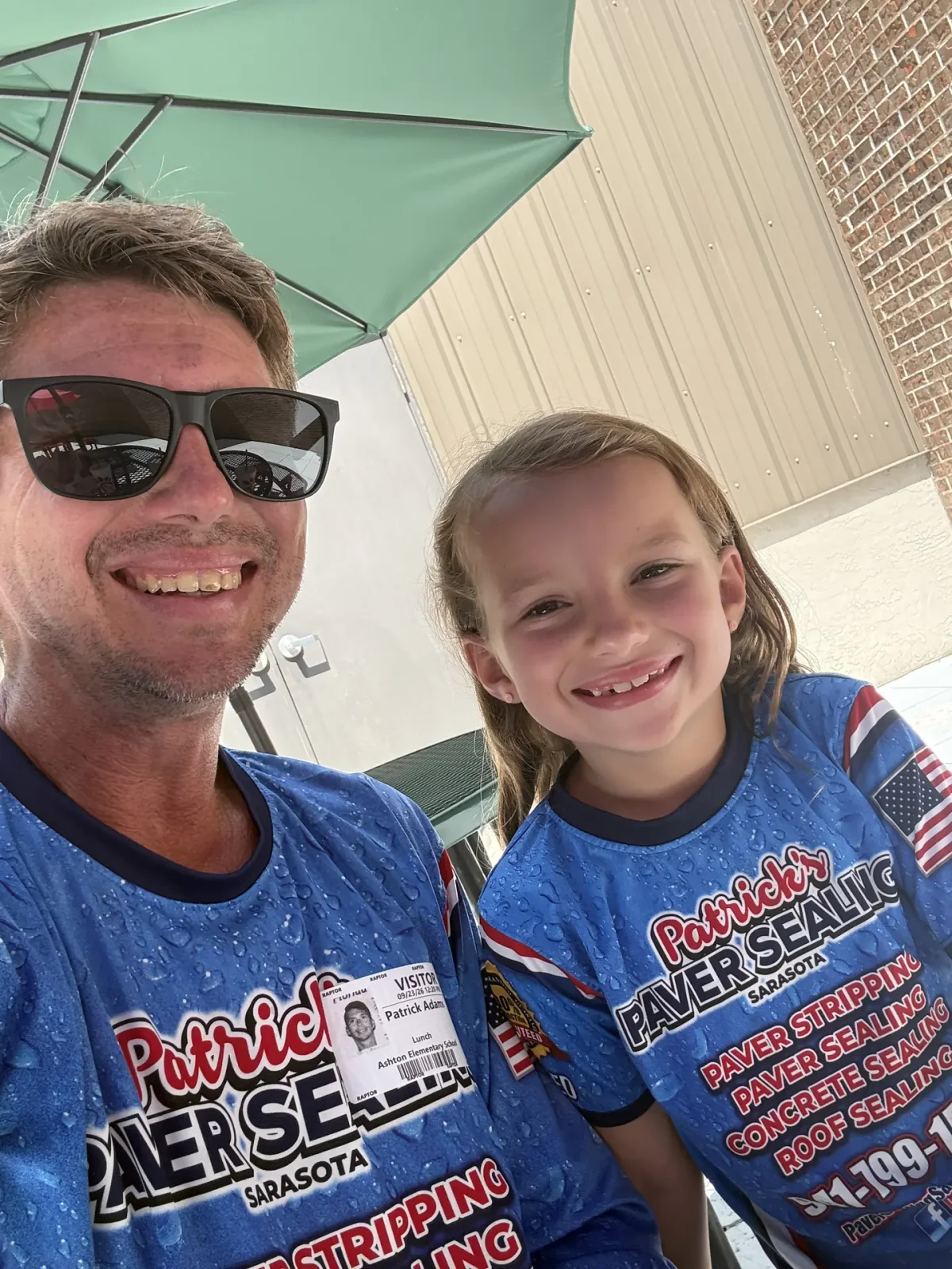A smiling man in a blue Patrick's jersey taking a selfie with a young girl in a matching jersey