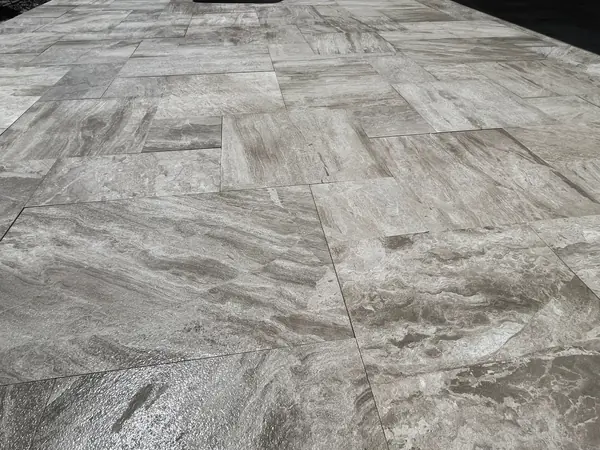 Close view of a grey veined stone tile floor with an irregular tile pattern