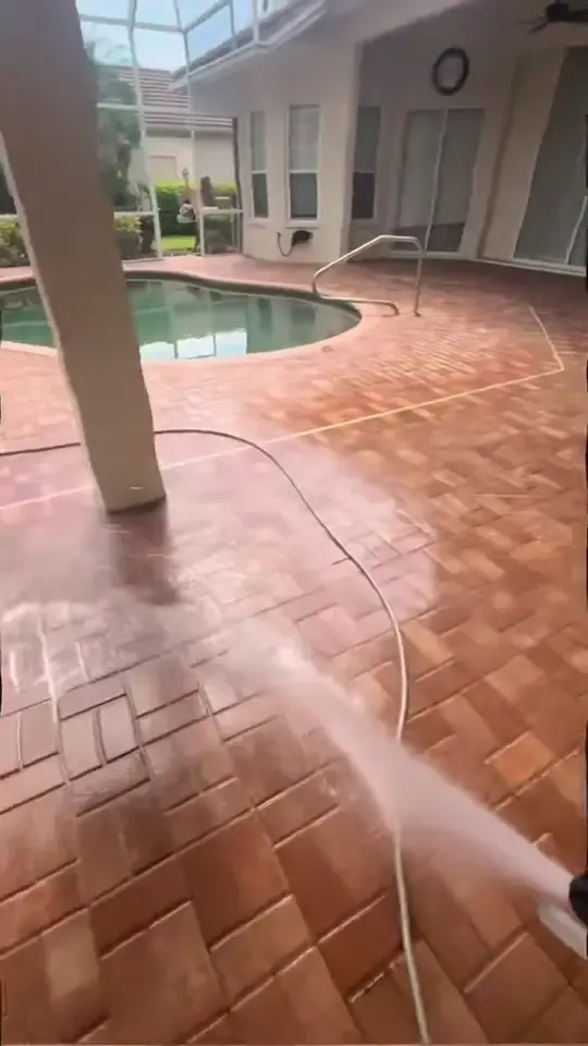 A surface cleaner and a rinse on a pool deck inside a screened lanai, ending on the finished deck.