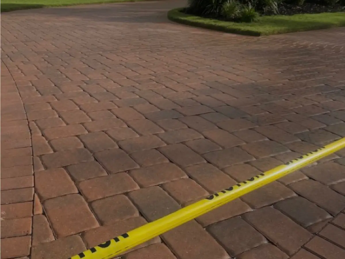 A driveway of red and brown pavers with their color back